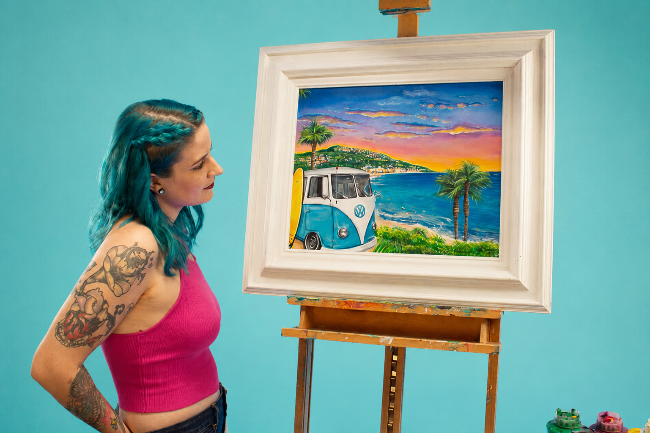 Woman with blue hair and tattoos standing next to a painting of a beach scene with a van on an easel.